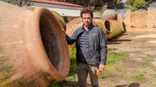 Antonio Serrano junto a varias de las tinajas que emplea para hacer vino en Villarrobledo (Albacete).