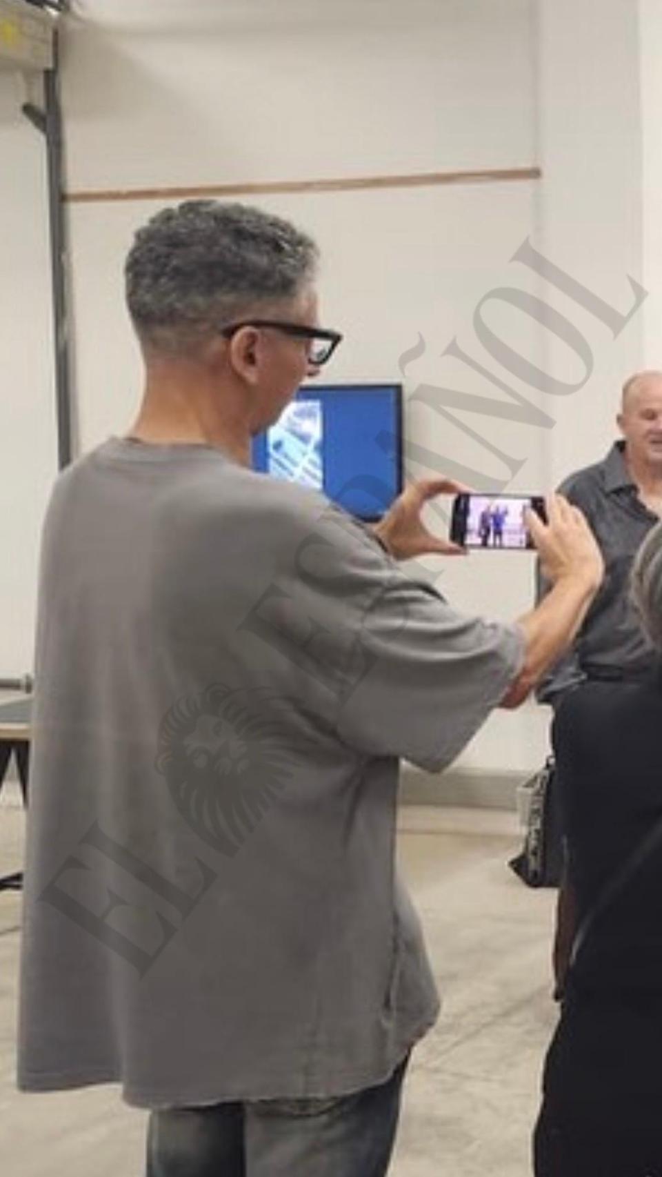 Ramos Soto, de pie, realiza fotografías con su móvil durante una exposición en la Fototeca de Cuba.