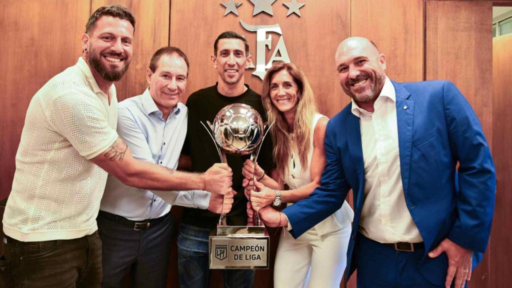 Posan con el polémico trofeo el presidente de Rosario Central, Gonzalo Belloso, la vicepresidenta Carolina Cristinziano, el DT Ariel Holan y los futbolistas Ángel Di María y Jorge Broun.