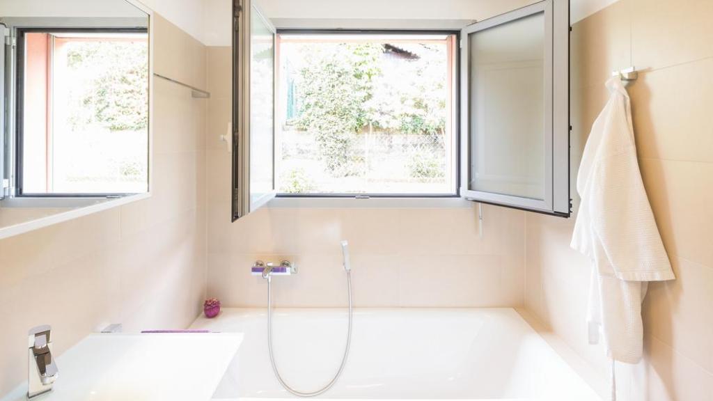 Un baño con la ventana abierta.