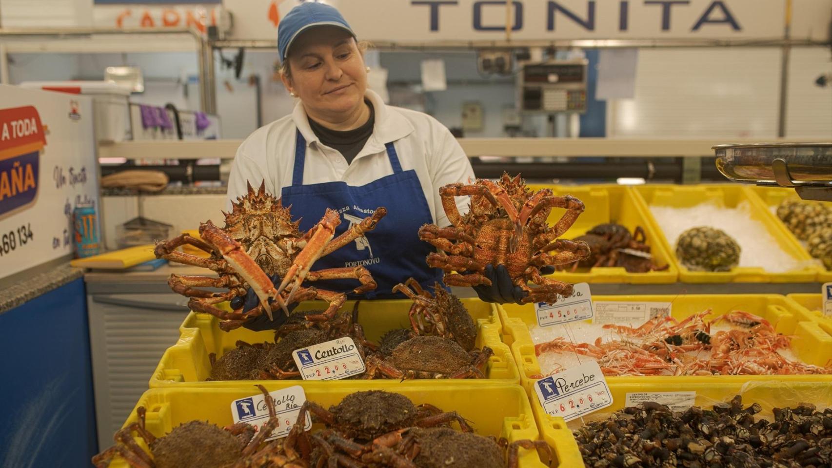 Una mujer muestra dos centollos en un puesto de la Plaza de Abastos en Portonovo, Sanxenxo, Pontevedra, en una imagen de archivo.