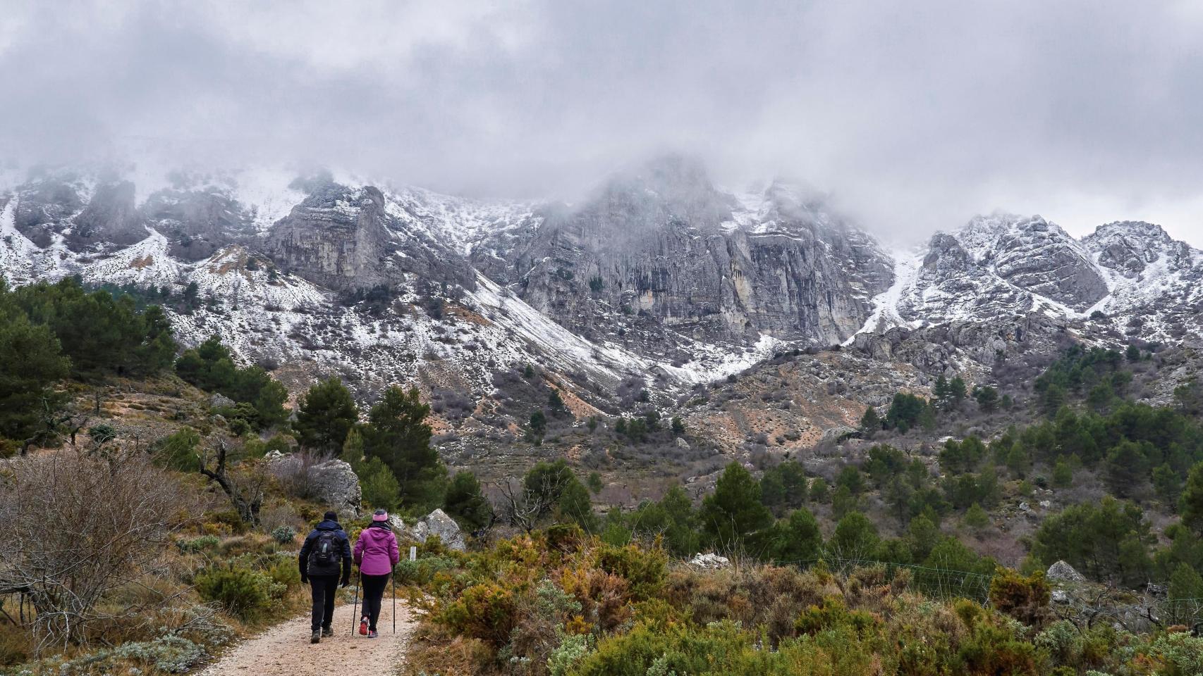 Una pareja camina por la Sierra de Aitana.