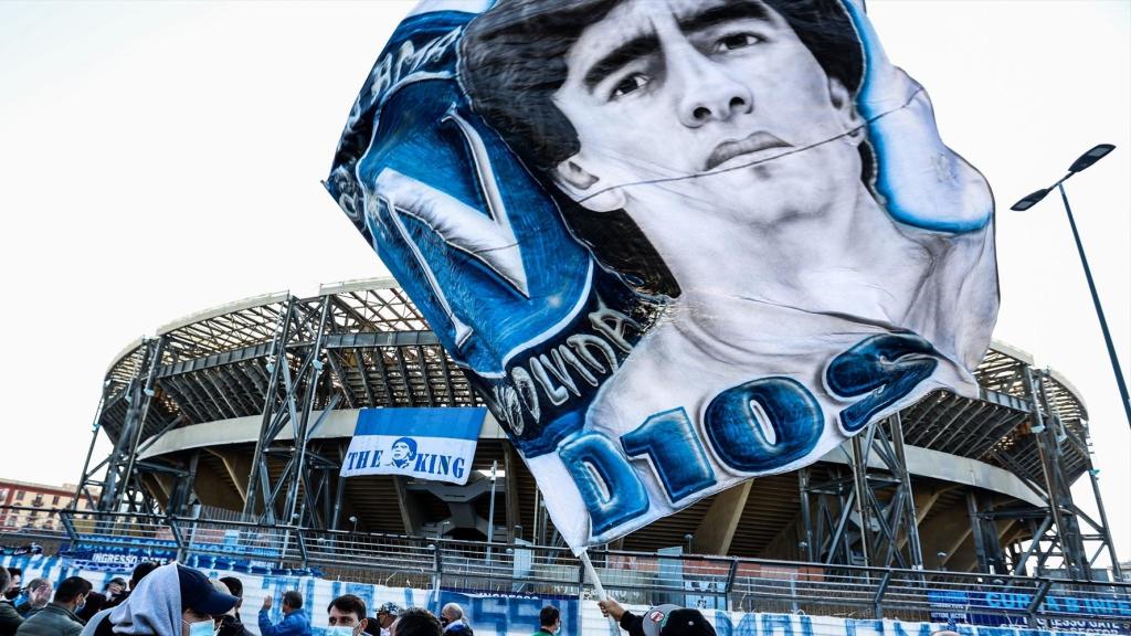 Un aficionado ondea una bandera con el rostro de Maradona en el exterior del estadio del Nápoles