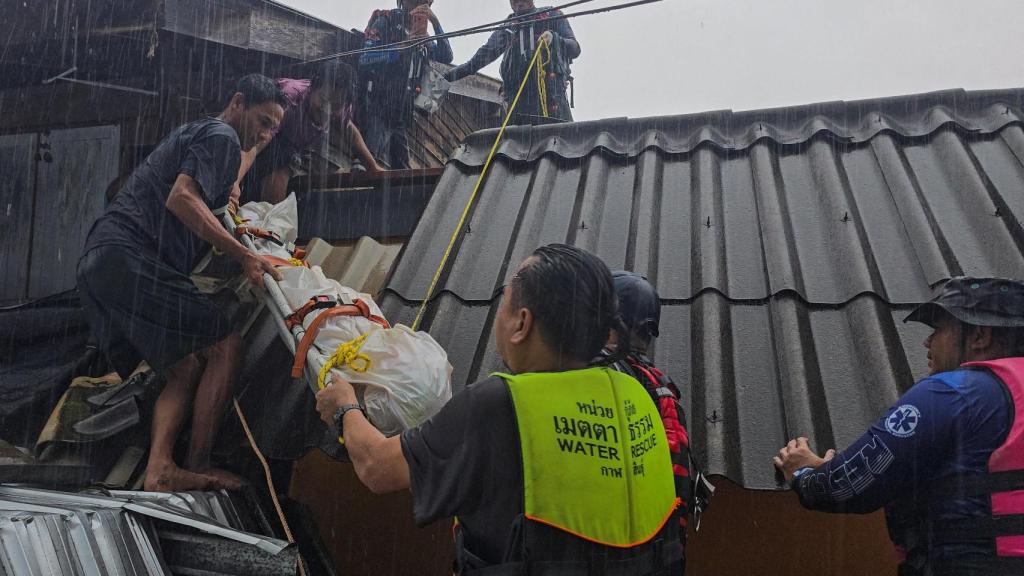Miembros de los equipos de rescate sacan el cuerpo de una víctima de su casa en Songkhla, Tailandia.