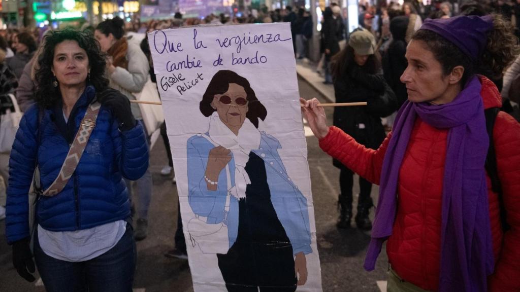Dos manifestantes sujetan una pancarta en homenaje a Gisèle Pelicot.