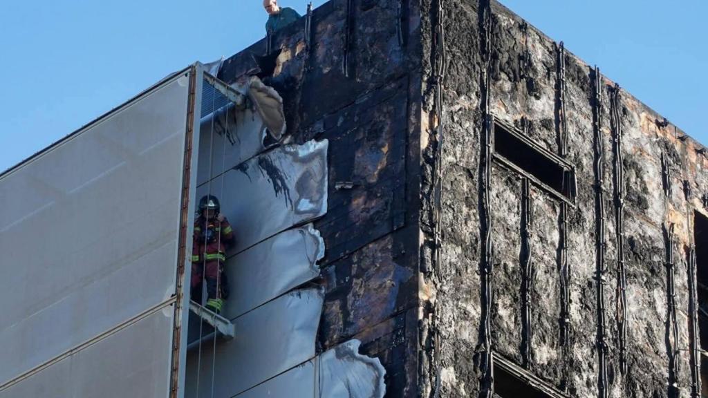 Un bombero revisando la fachada calcinada del Hospital Santa Lucía.