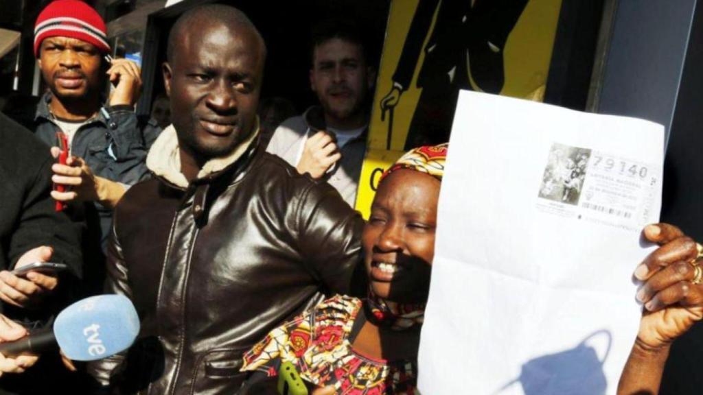 Ngagne y su esposa con el boleto ganador de el Gordo de la Lotería de Navidad.