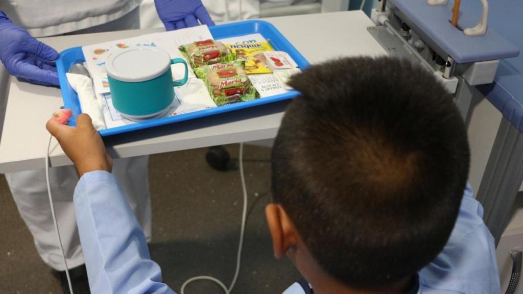 Un niño recibe su bandeja del desayuno en un hospital de Madrid.