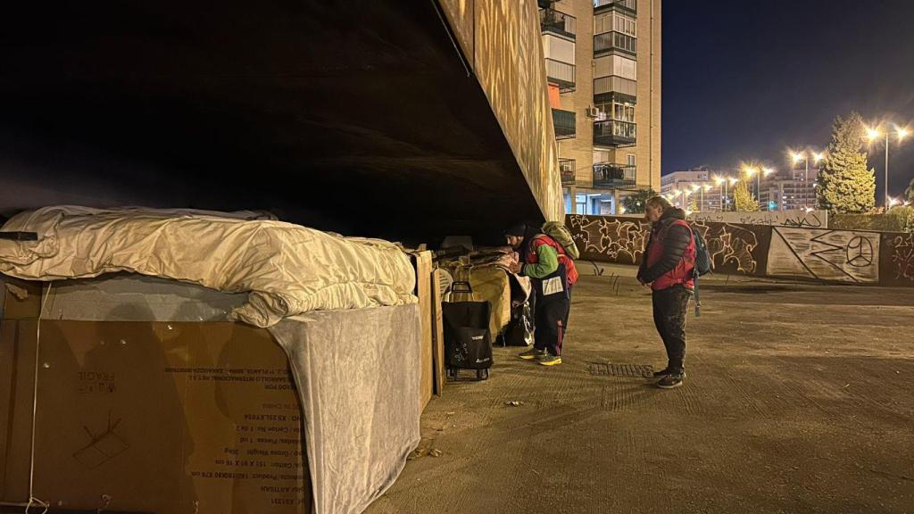 Los voluntarios preguntando a una de las personas sin hogar, en Delicias.