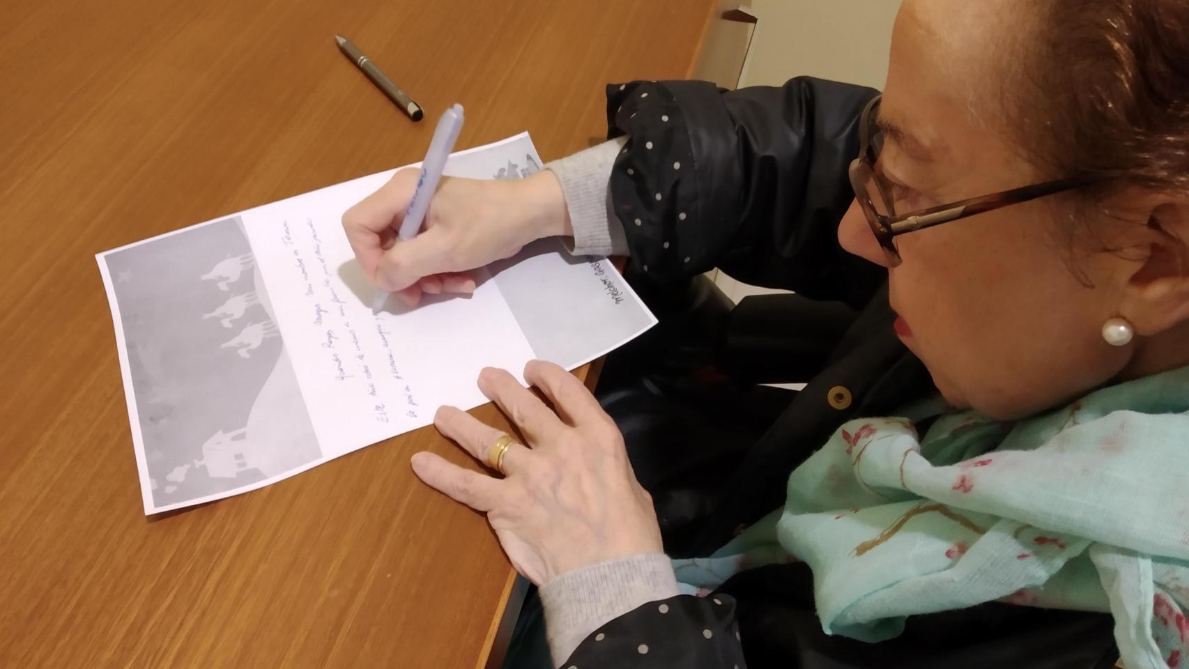 Una mujer escribe una carta por Navidad.