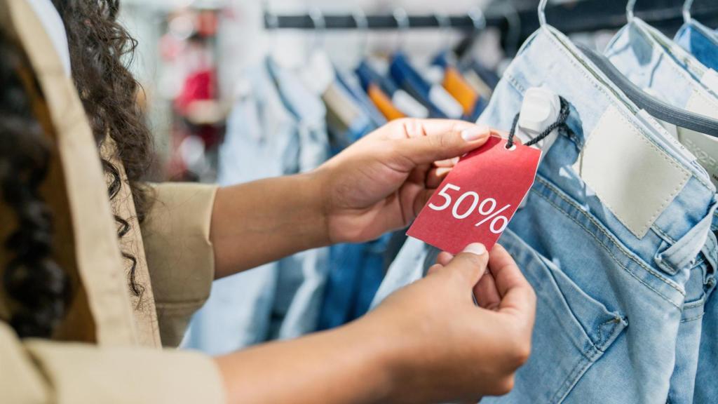 Una mujer comprando ropa en oferta.