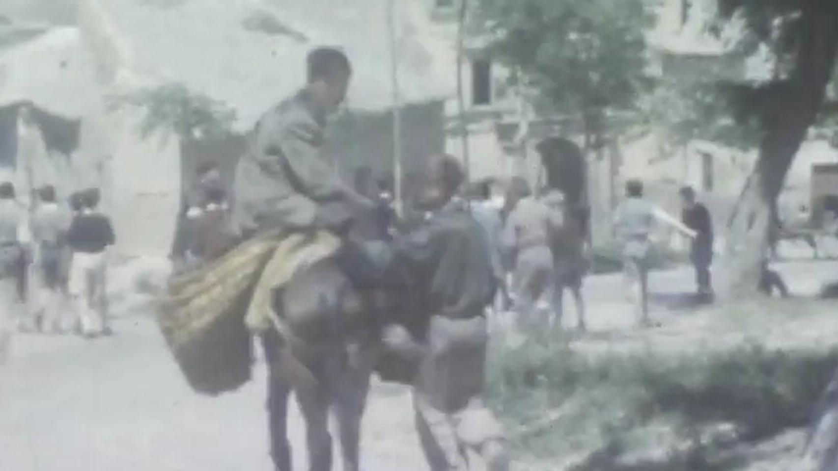 Un niño toledano monta en burro junto a la Puerta del Cambrón de Toledo en los años 40.