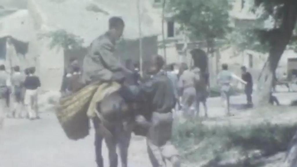 Un niño toledano monta en burro junto a la Puerta del Cambrón de Toledo en los años 40.