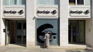Una mujer saca dinero de una oficina de Ibercaja en Madrid.