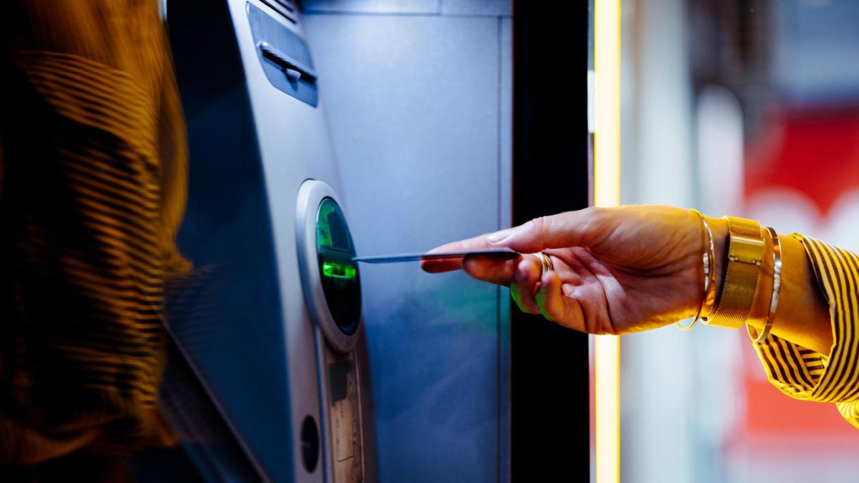 Una mujer sacando dinero en un cajero automático.