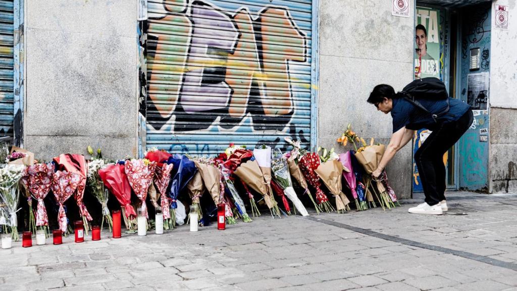 Una mujer deposita un ramo de flores a 5 de julio de 2023 en la tienda Vistebien donde días antes habían apuñalado a Concha, la dueña del establecimiento, en la Plaza de Tirso de Molina.