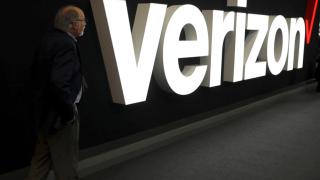 Man in front of Verizon logo.