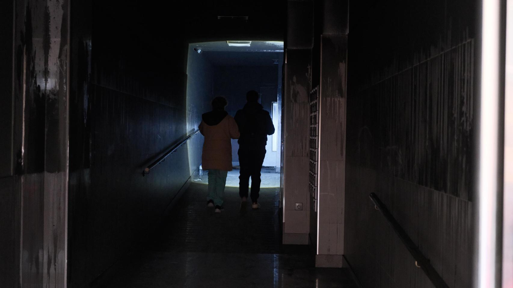 Dos vecinos caminan entre los restos del incendio esta mañana.