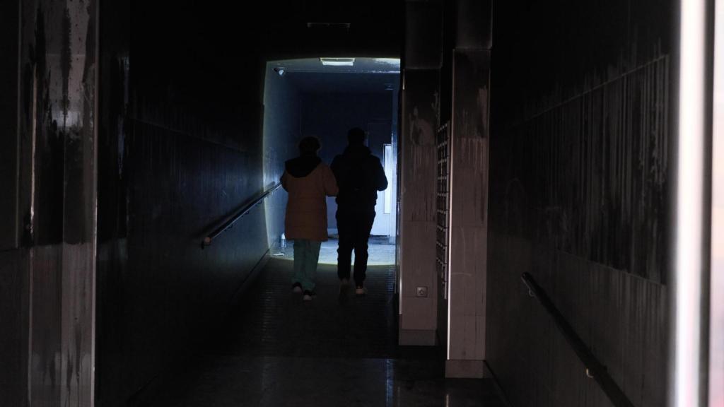 Dos vecinos caminan entre los restos del incendio esta mañana.