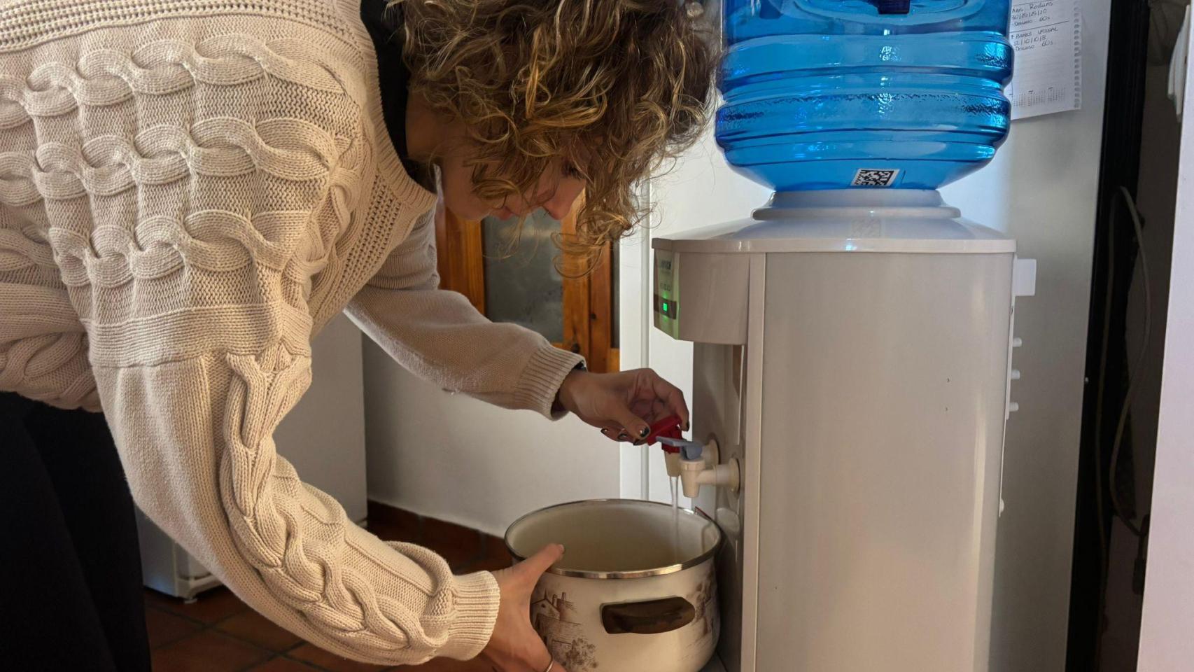 Una joven, vecina de Chimillas, llenando una olla de agua.