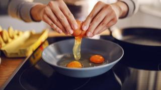 Mujer cocinando con huevos.
