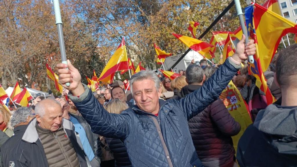 Un asistente a la concentración en el Templo de Debod (Madrid) sostiene un cartel con el rostro de Sánchez y los casos judiciales que envuelven a su círculo.