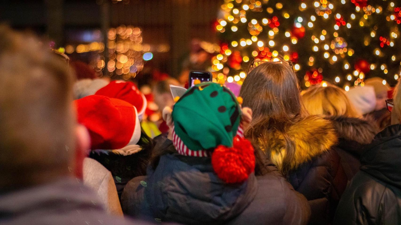 Un grupo de personas contemplan el cambio de luces navideñas