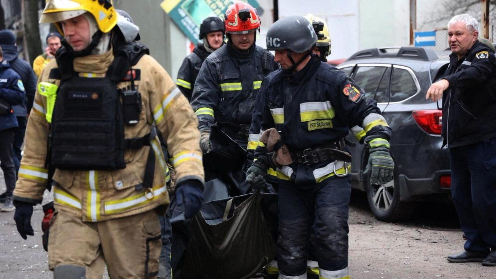 Rescatistas transportan el cadáver de unos los fallecidos en el ataque ruso contra Dnipró este lunes.