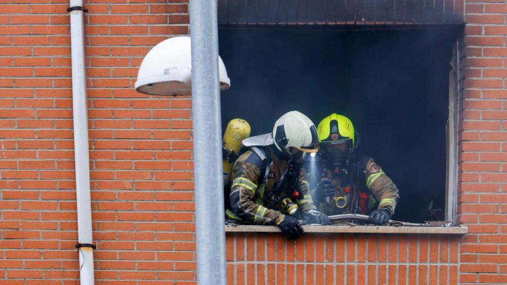 Bomberos inspeccionando la vivienda afectada.