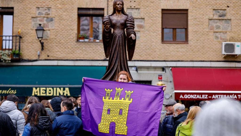 Sara posa con la bandera de Castilla delante de la escultura de María Pacheco, figura clave del siglo XVI.