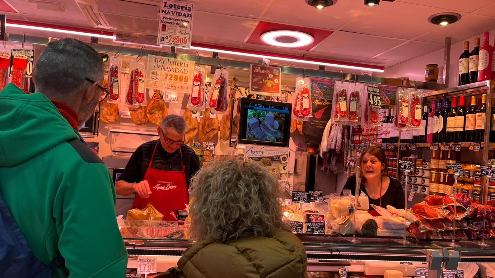 Personas comprando en la Charcutería jamonería Montori Barranco del Mercado Central.