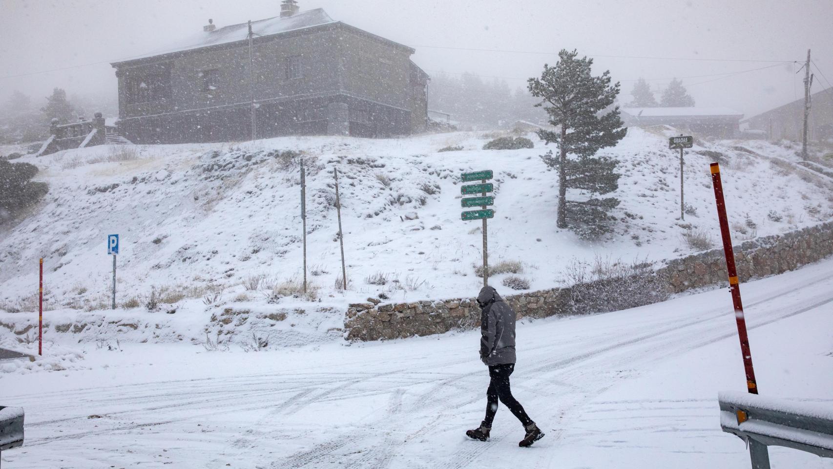 Un hombre camina por la nieve en el Puerto de Navacerrada.