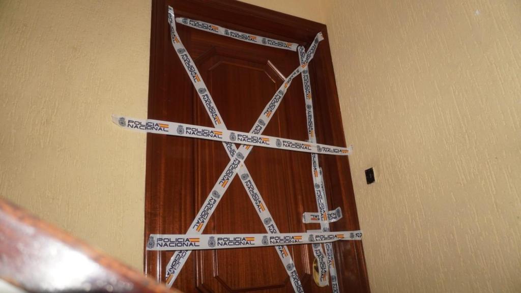 La puerta de la vivienda donde ocurrió el crimen con el precinto policial.