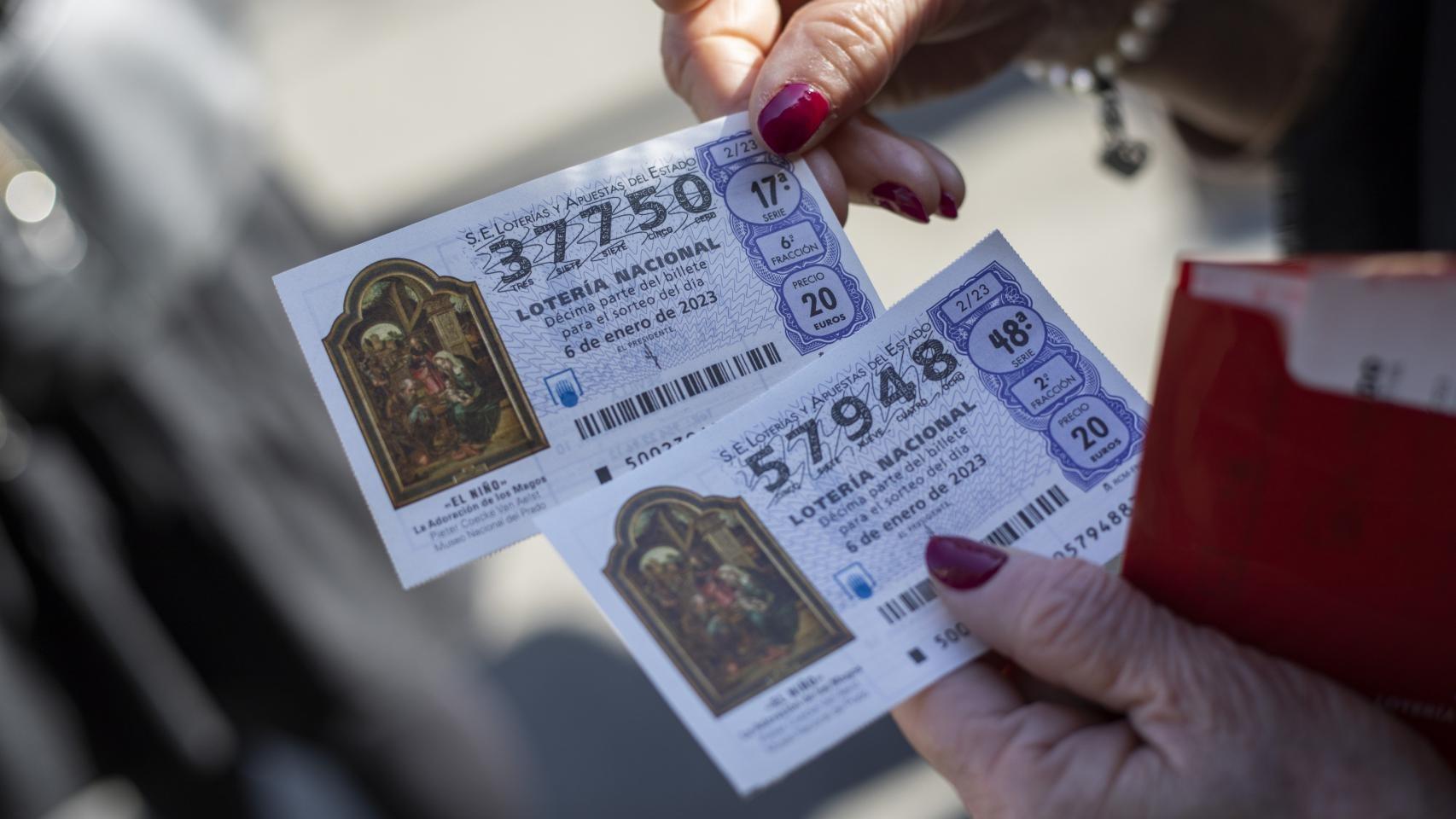 Una mujer sujeta dos décimos de Lotería