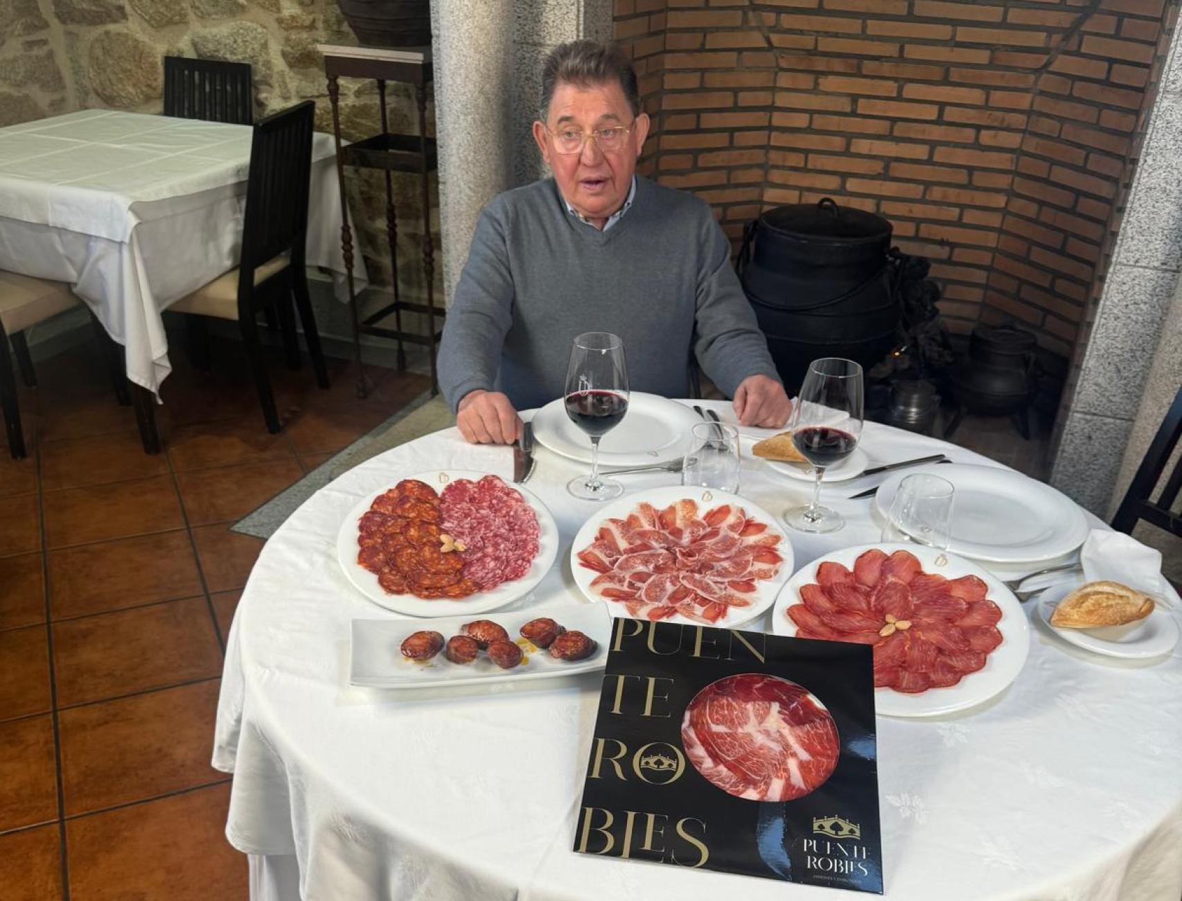 Cesáreo padre sentado a la mesa con sus chorizos