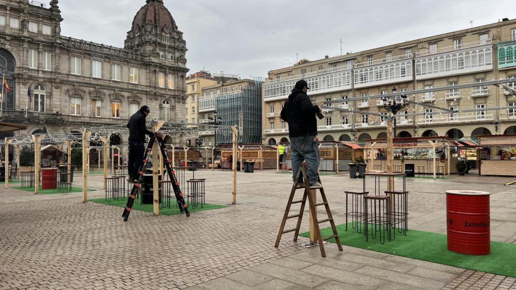 Varios operarios trabajando esta tarde en la instalación de luces.