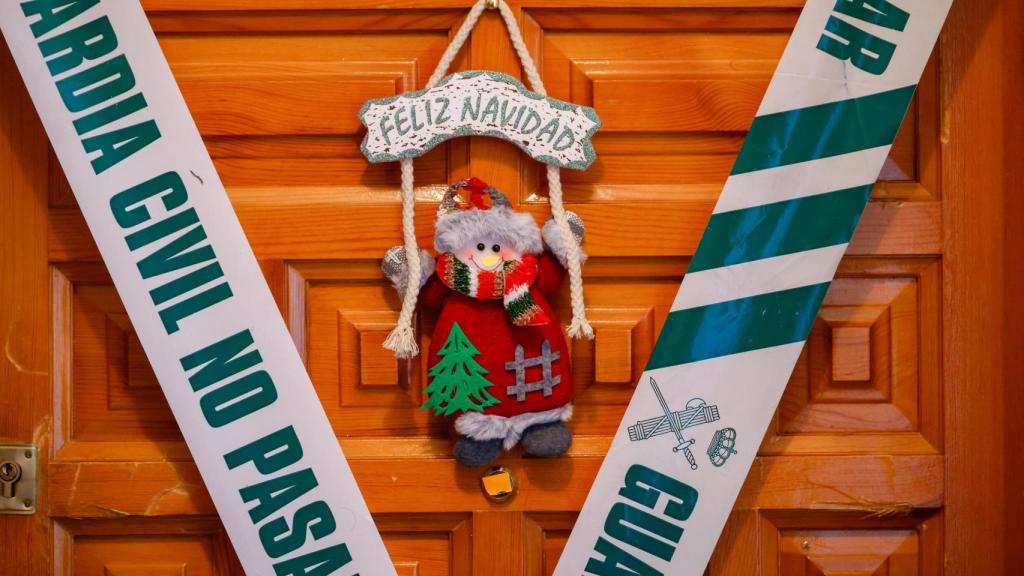 El precinto de la Guardia Civil y la decoración de 'Feliz Navidad' contrastan en la puerta del domicilio familiar en la calle Cirilo Montero de Torrijos.