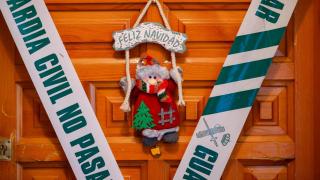 El precinto de la Guardia Civil y la decoración de 'Feliz Navidad' contrastan en la puerta del domicilio familiar en Torrijos, donde ocurrió un presunto crimen de violencia de género.