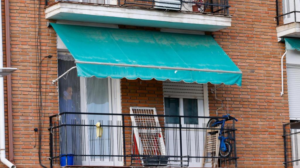Balcón de la vivienda, donde se aprecian una pequeña bicicleta y un tendedero, símbolos de la vida cotidiana en el domicilio.
