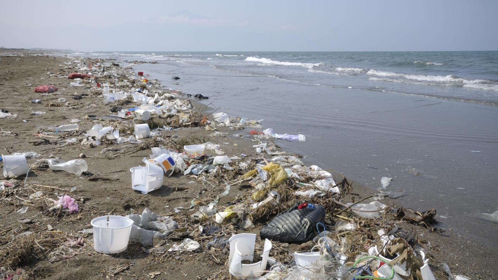 Contaminación por plásticos en la orilla de una playa.