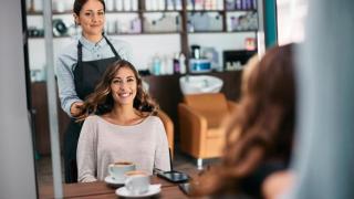 Peluquera con su clienta frente al espejo.