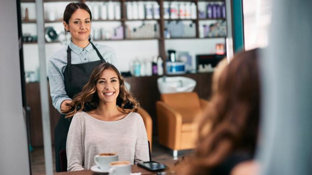 Peluquera con su clienta frente al espejo.