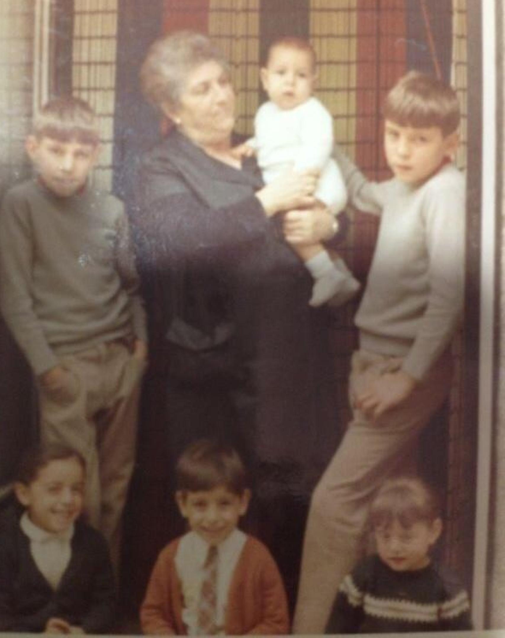 Remedios a la puerta de la tienda que tenía en Benavente con sus nietos en los años 60