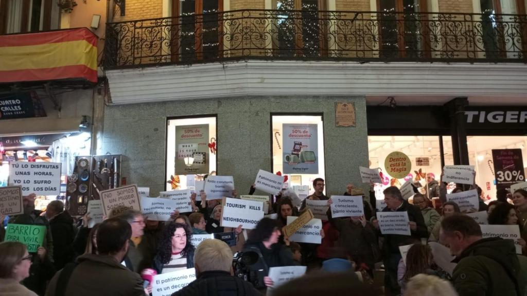 Los manifestantes portan carteles con mensajes como 'Somos vecinos, no somos un museo' y 'El turismo mata el vecindario' reclamando la habitabilidad del barrio.