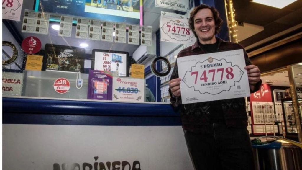 Francisco Lago, en la administración de loterías de Marineda City, con el cartel del quinto premio entregado.