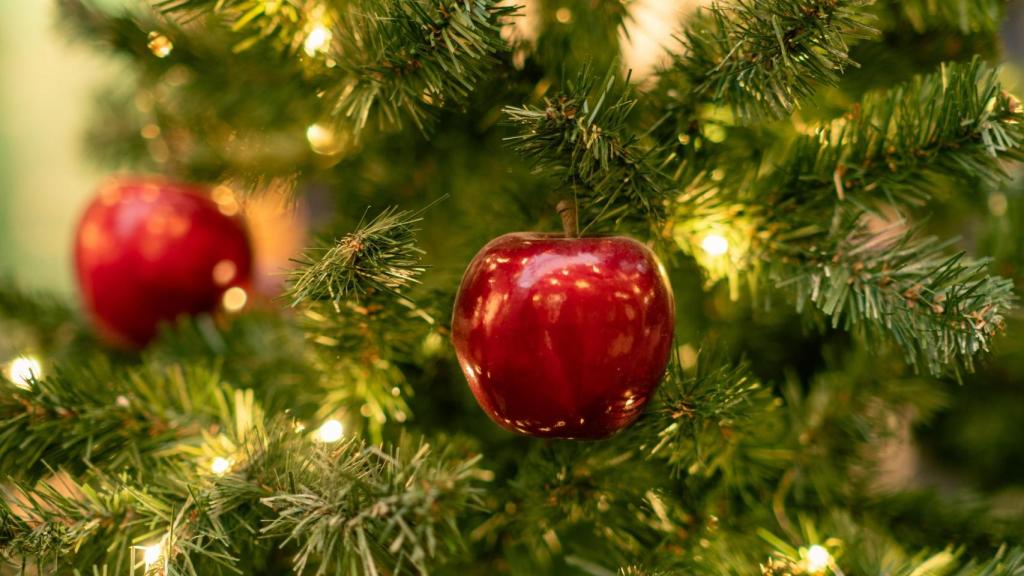 Un árbol de Navidad con manzanas decorativas.