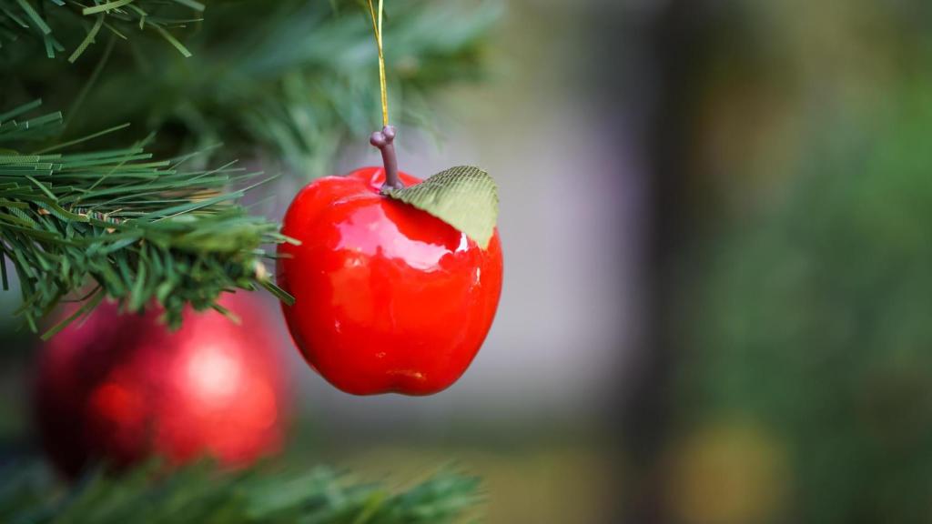 Una manzana decorativa colgando de un árbol de Navidad.