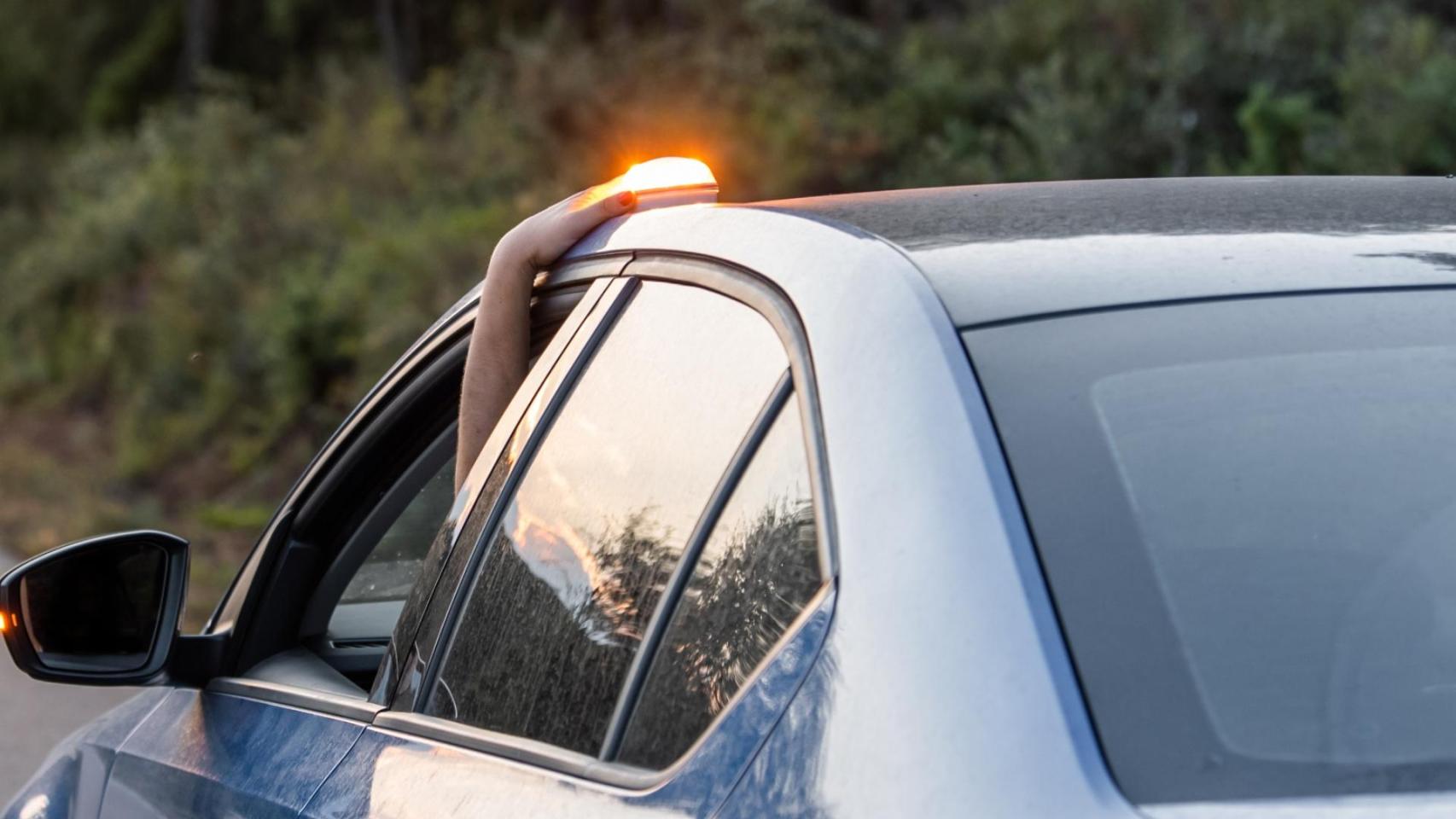 Un conductor coloca la baliza V-16 en el techo del coche