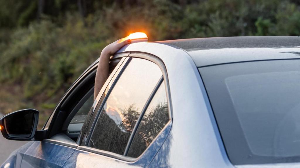 Un conductor coloca la baliza V-16 en el techo del coche