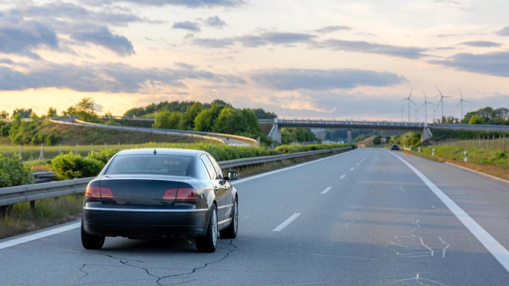 Un coche circulando por una carretera agrietada